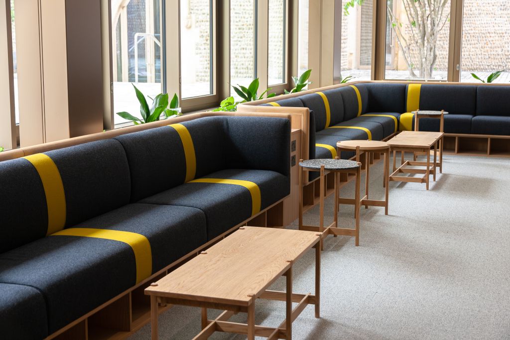 banquette seating wraps around the room in oak and grey frabic with a yellow stripe